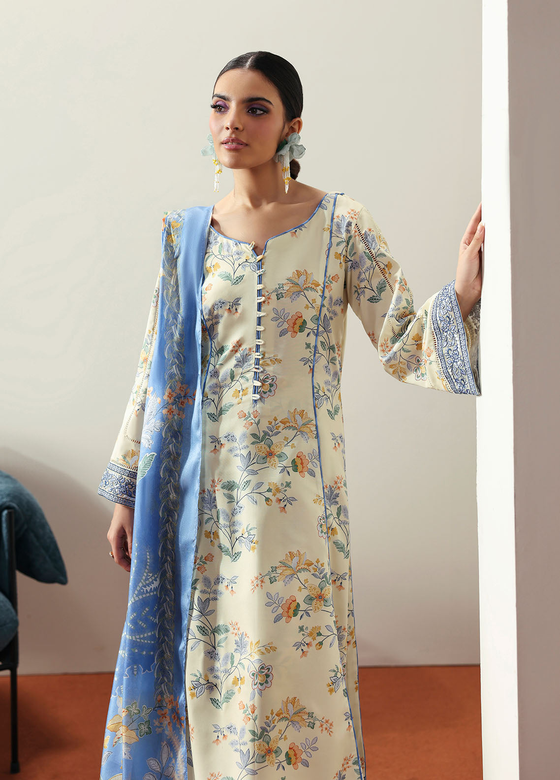 Model wearing cream and blue floral outfit from Gulaal Basics | Elaris, elegant Pakistani luxury pret available online in UK.