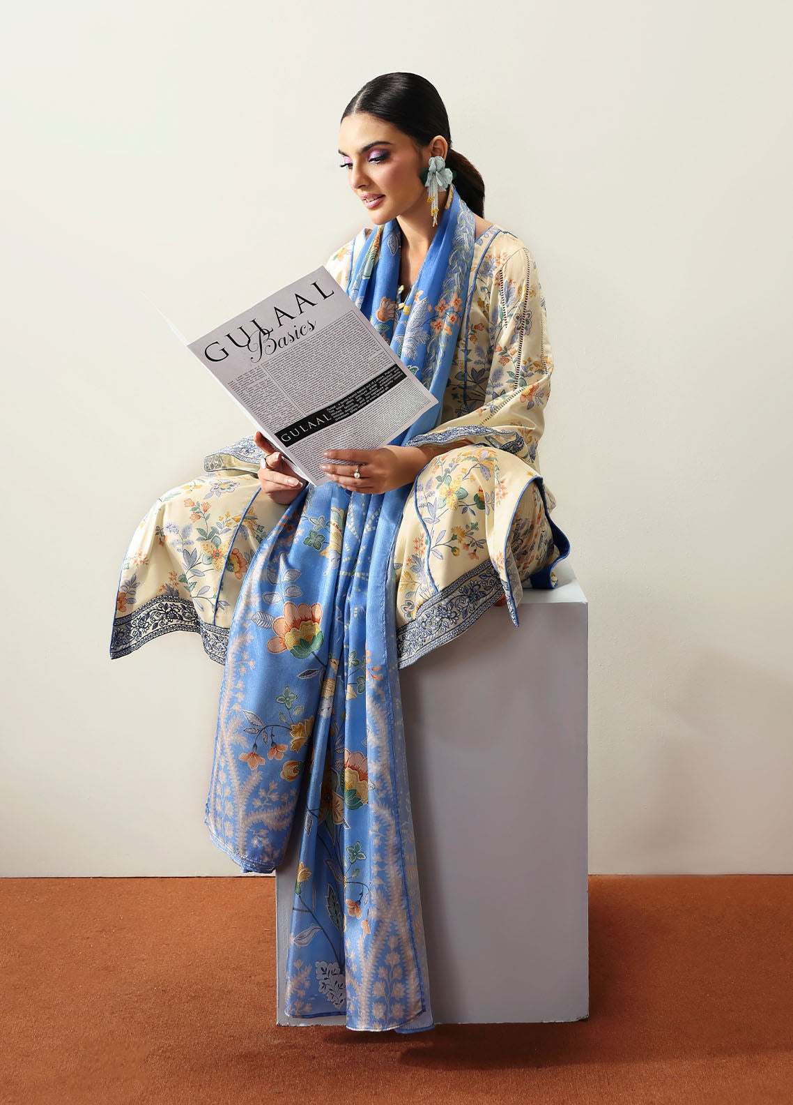 Model wearing cream and blue floral outfit from Gulaal Basics | Elaris, elegant Pakistani luxury pret available online in UK.