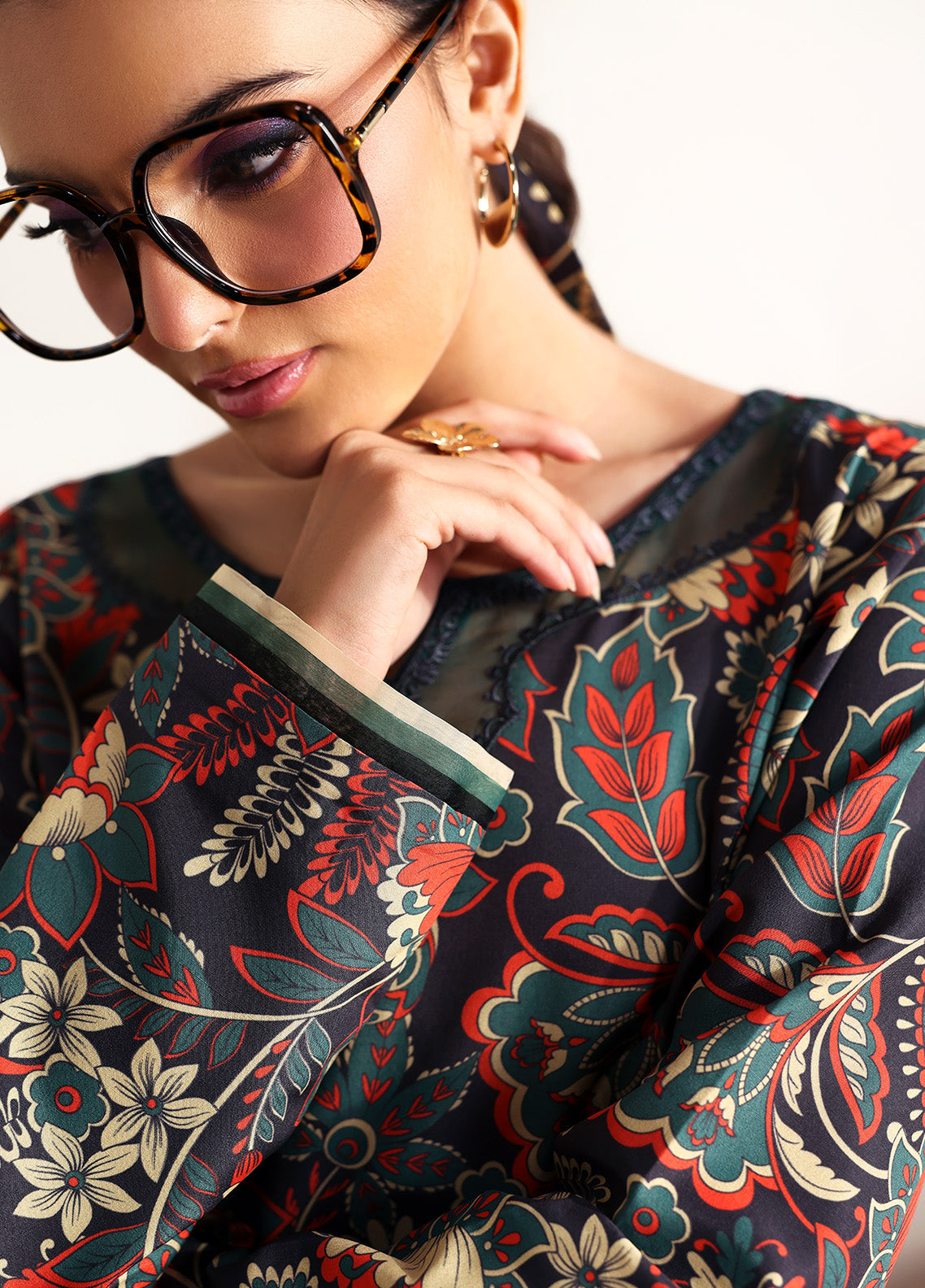 Model wearing Terrie from Gulaal in a dark green printed co-ord set with red and beige floral motifs, ideal for Pakistani luxury pret in the UK.