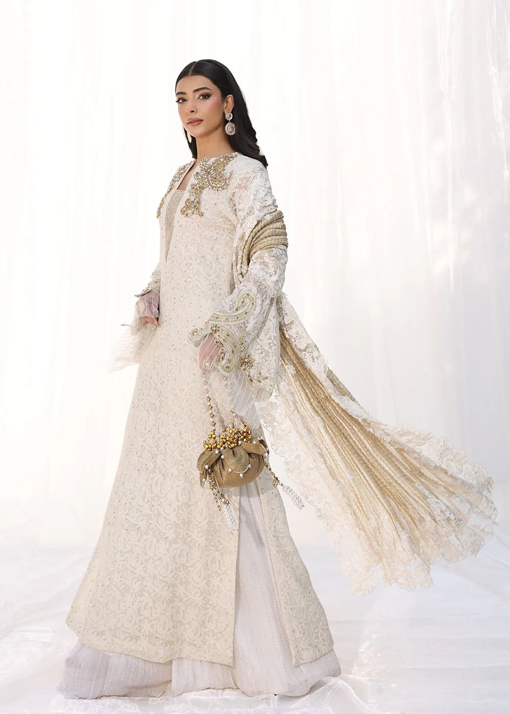 Model wearing off-white and gold embellished dress with lace detailing and dupatta from Musferah Saad Royal Pearl, Pakistani Luxury pret in UK.