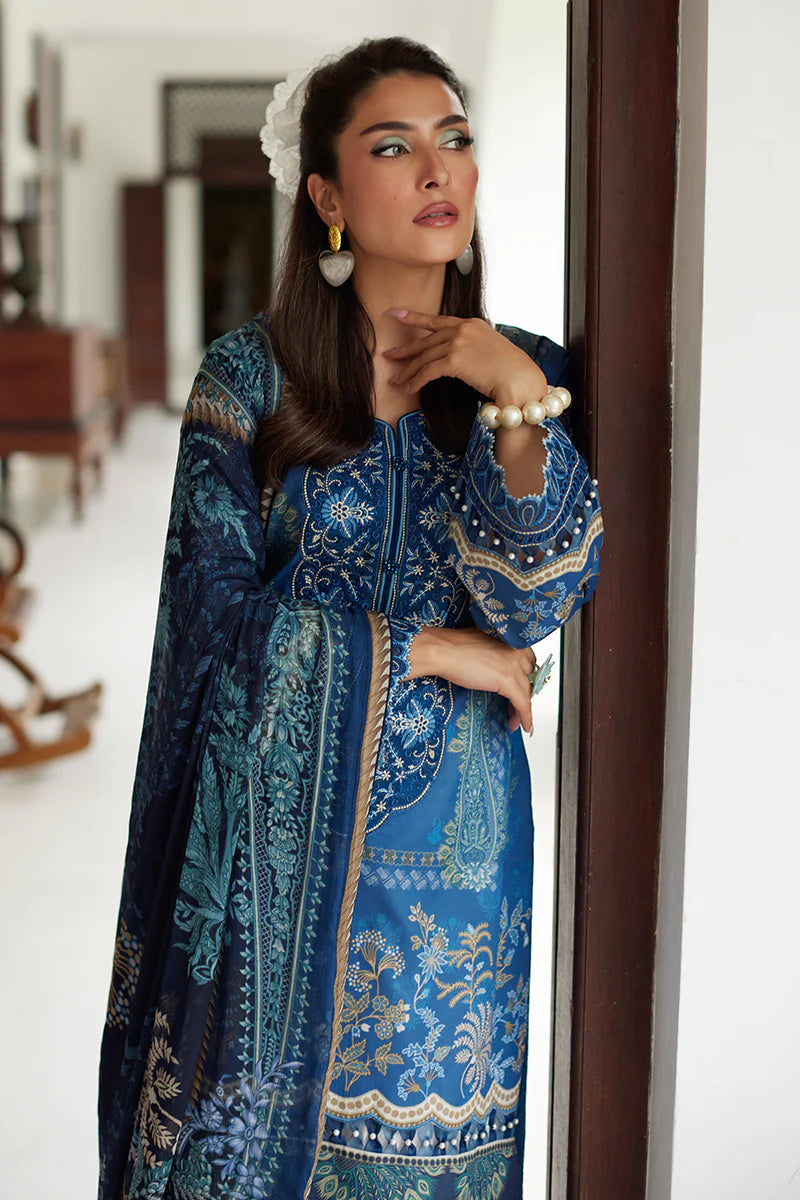 Model wearing Gulaal Saffira Lawn '25 Aadhya in deep blue with intricate embroidery and a printed dupatta. Shop Pakistani luxury pret online in the UK.