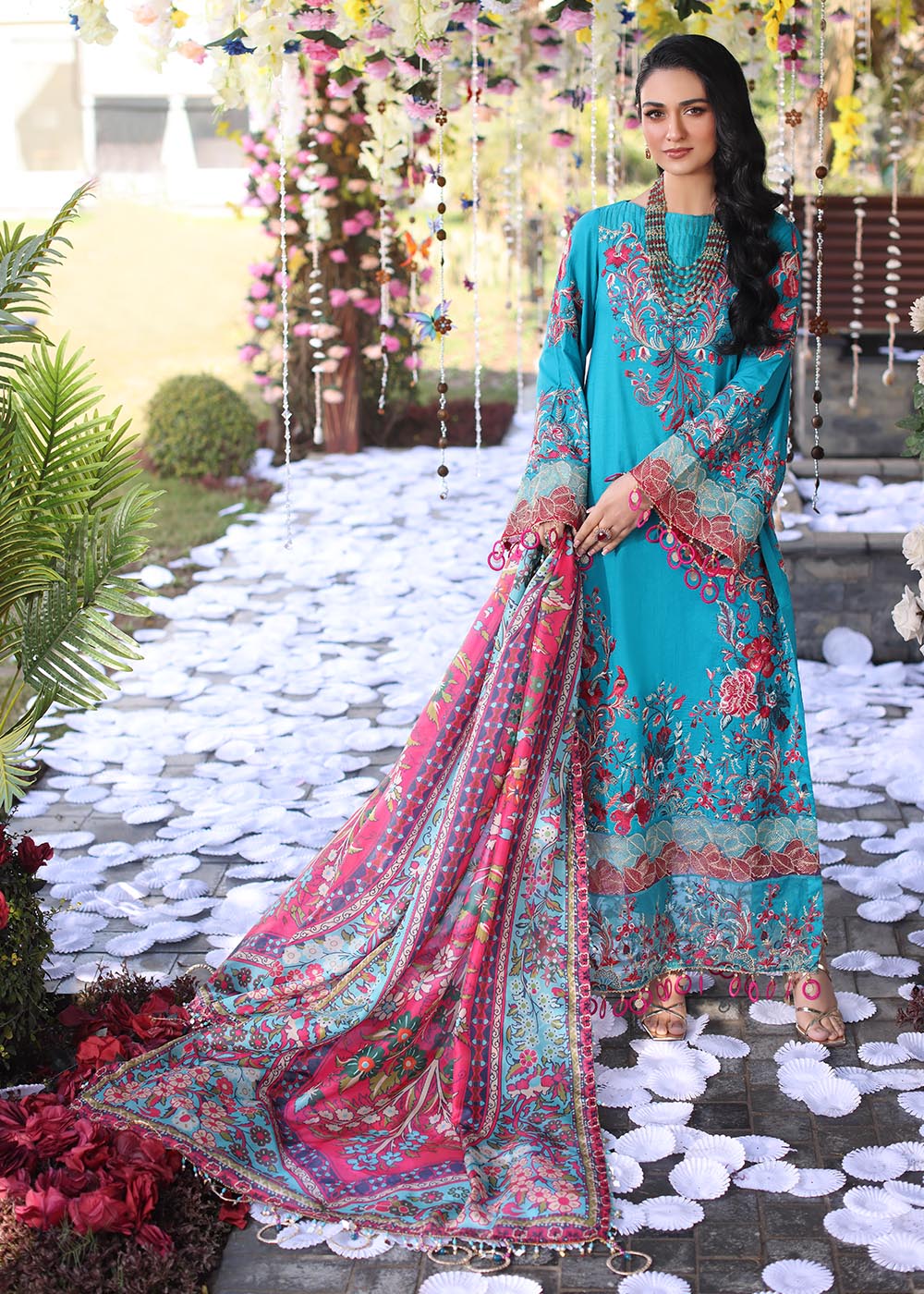 Model wearing teal and pink floral embroidered dress from Musferah Saad Pretty Girls Luxury Lawn 2025 Celestia. Pakistani clothes online UK.