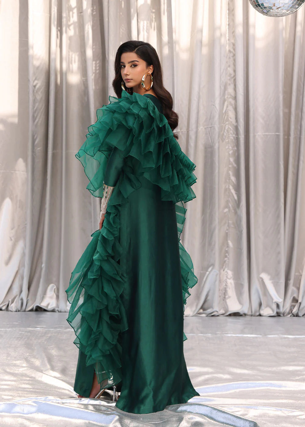 Model wearing emerald green dress with ruffled sleeves and embellished neckline from Musferah Saad Emerald Chic, Pakistani Luxury pret in UK.