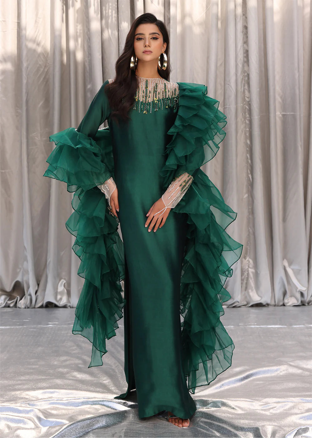 Model wearing emerald green dress with ruffled sleeves and embellished neckline from Musferah Saad Emerald Chic, Pakistani Luxury pret in UK.
