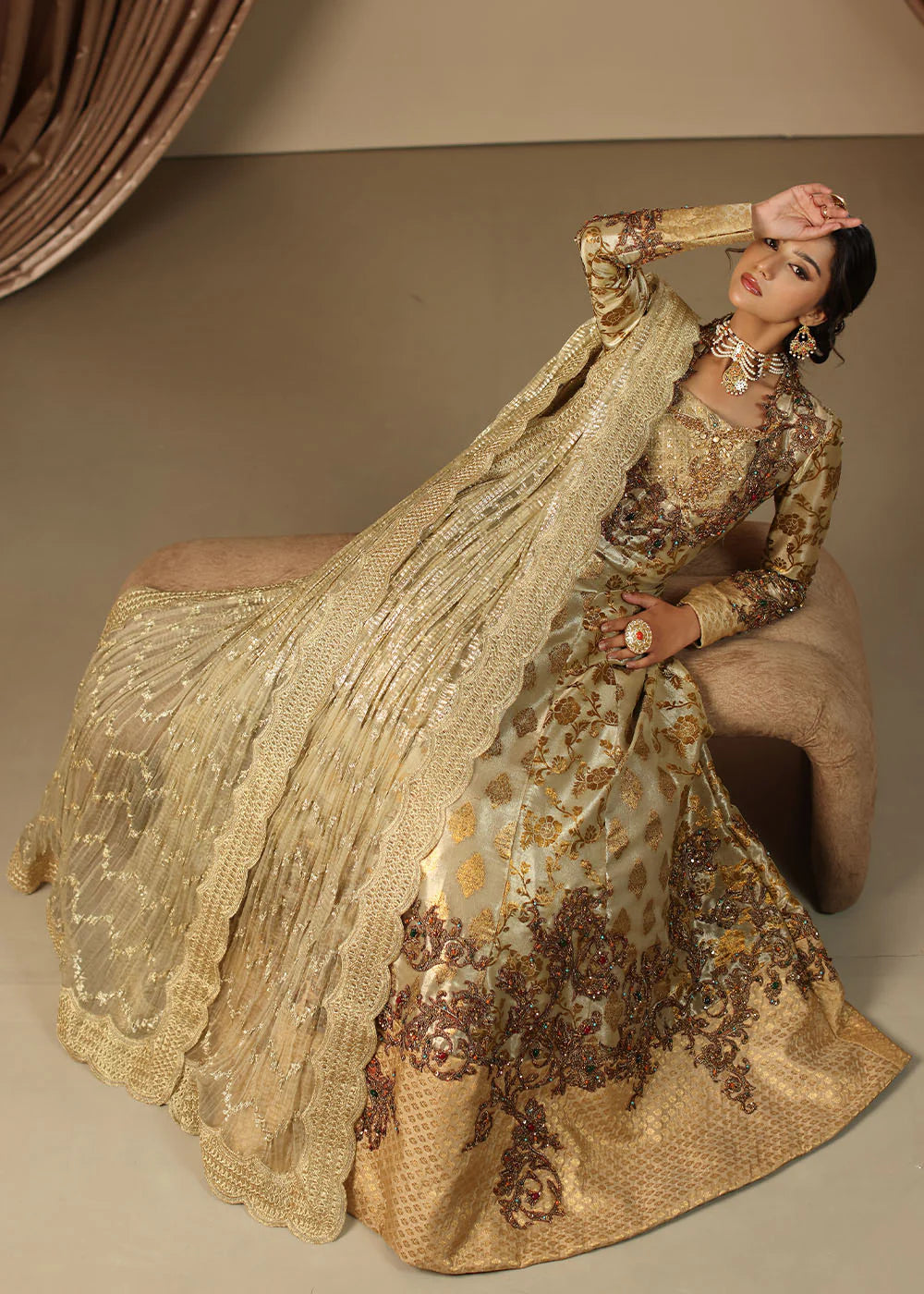 Model wearing gold heavily embroidered dress from Musferah Saad Eternal Grace, Pakistani luxury pret available online in UK.