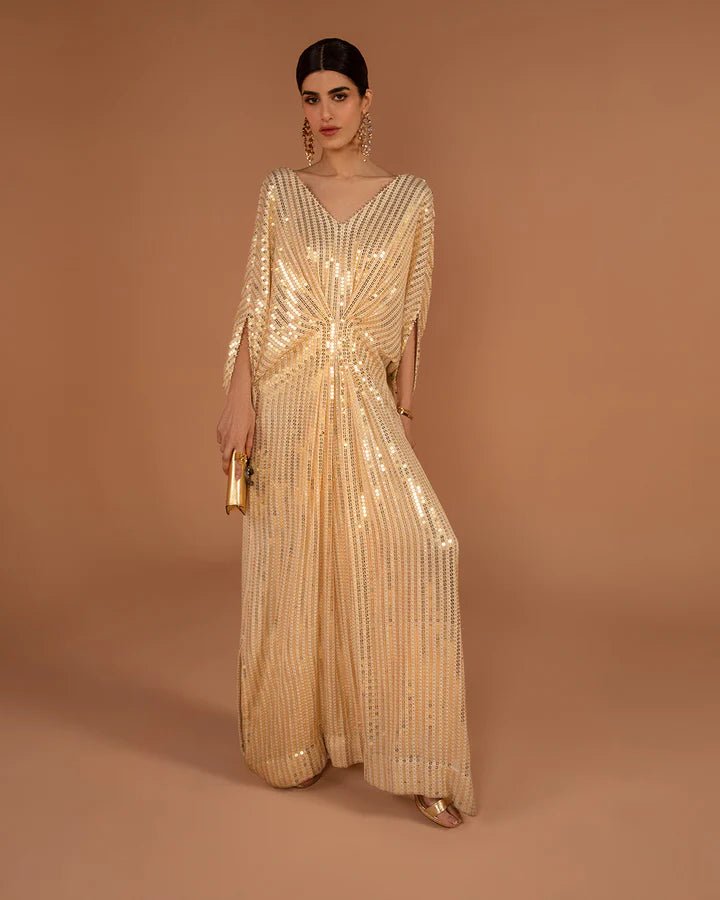 Model wearing a gold Beyza dress from Faiza Saqlain's Aleira Evening Edit '24 collection. Pakistani clothes online in UK.
