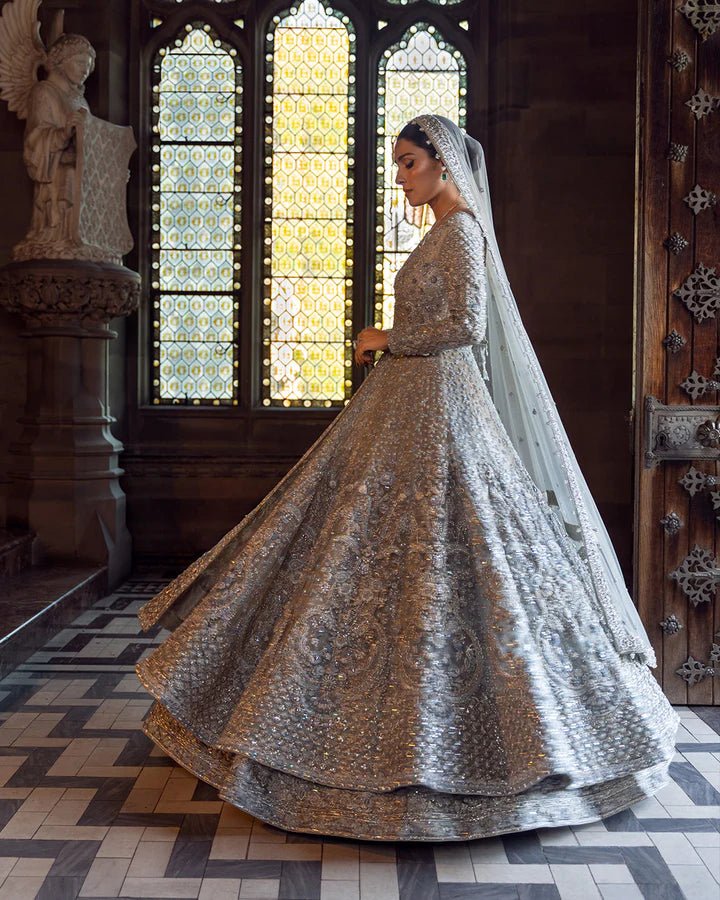 Model wearing a silver Ayana bridal dress by Faiza Saqlain with intricate embellishments, ideal for Pakistani weddings, available online in the UK.