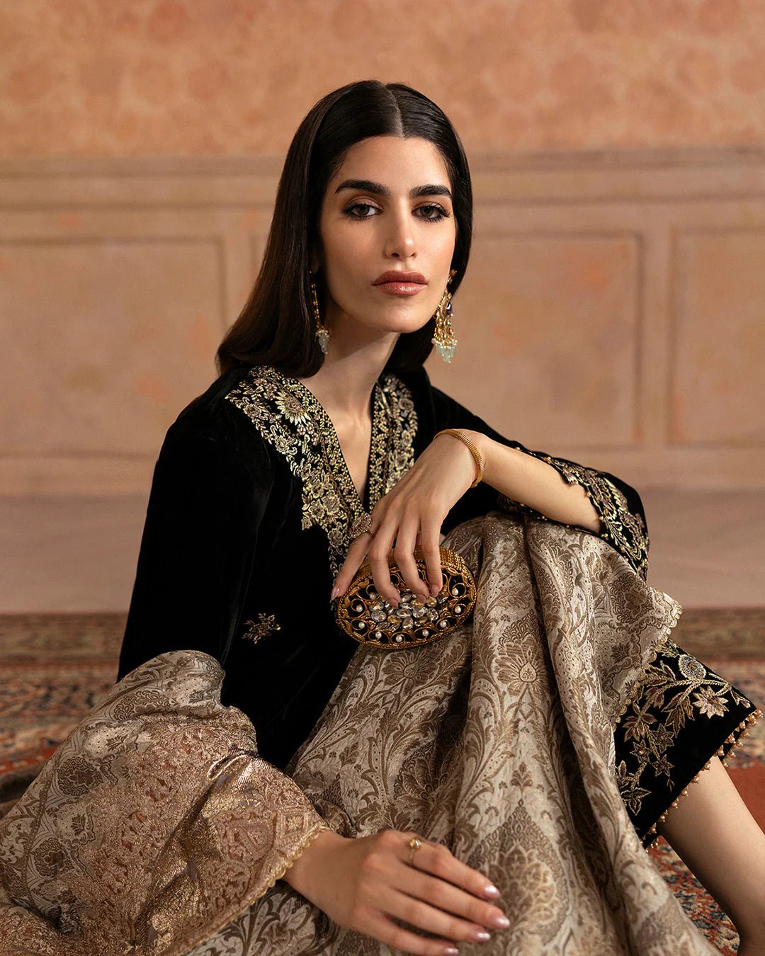 Model wearing Faiza Saqlain Ismene Velvet Vita dress in black with luxurious gold embroidery. Shop Pakistani bridal dresses online in the UK now.