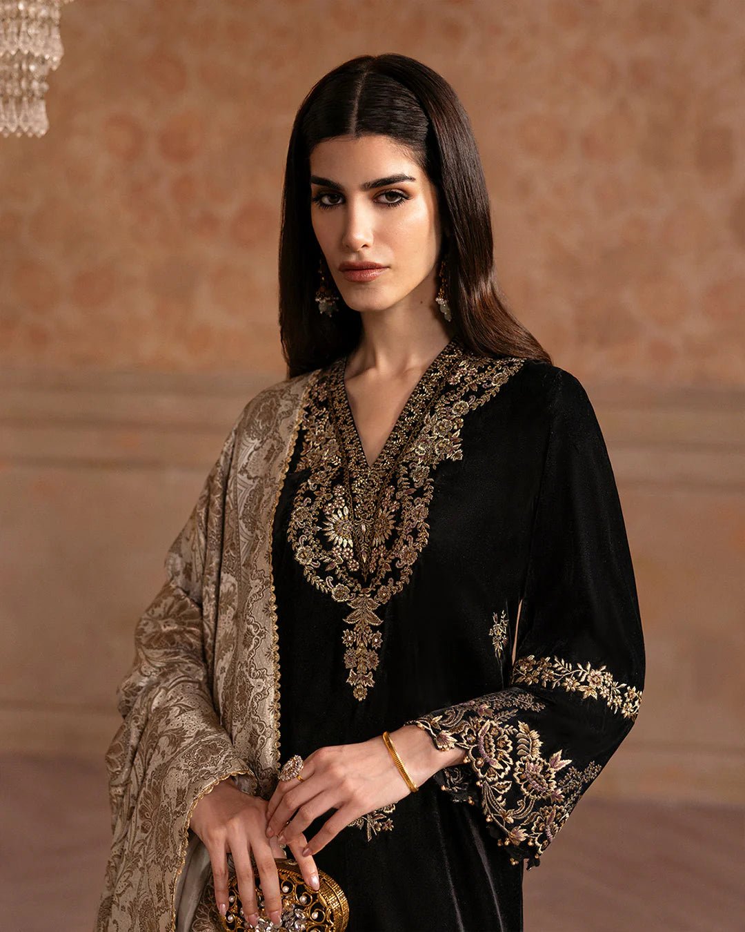 Model wearing Faiza Saqlain Ismene Velvet Vita dress in black with luxurious gold embroidery. Shop Pakistani bridal dresses online in the UK now.