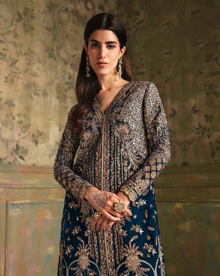 Model wearing a blue Haanie dress with intricate gold embroidery from Faiza Saqlain's Luxe Formals Manaar Nov '23 collection. Pakistani clothes online in UK.