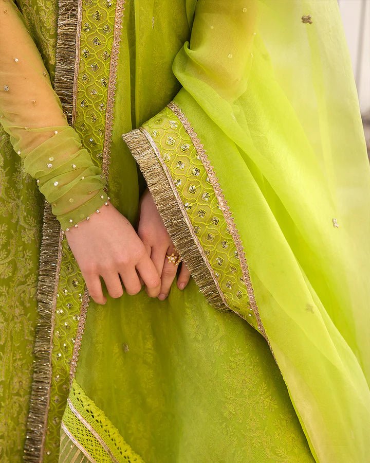 Model wearing a lime green Reya dress with intricate embellishments from Faiza Saqlain's Aleira Evening Edit '24 collection. Pakistani clothes online in UK.