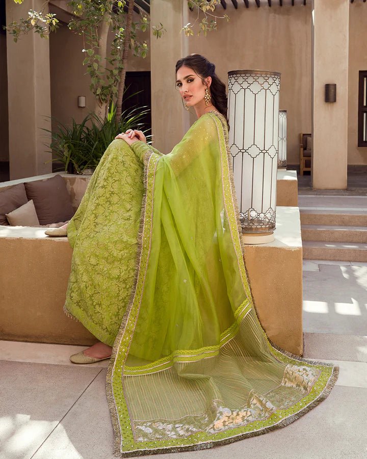 Model wearing a lime green Reya dress with intricate embellishments from Faiza Saqlain's Aleira Evening Edit '24 collection. Pakistani clothes online in UK.