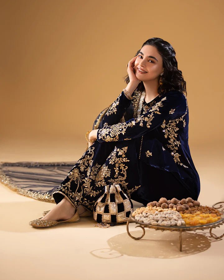 Model wearing a navy blue Sayonee dress with gold embroidery from Faiza Saqlain'sMakhmal collection. Pakistani clothes online in UK.