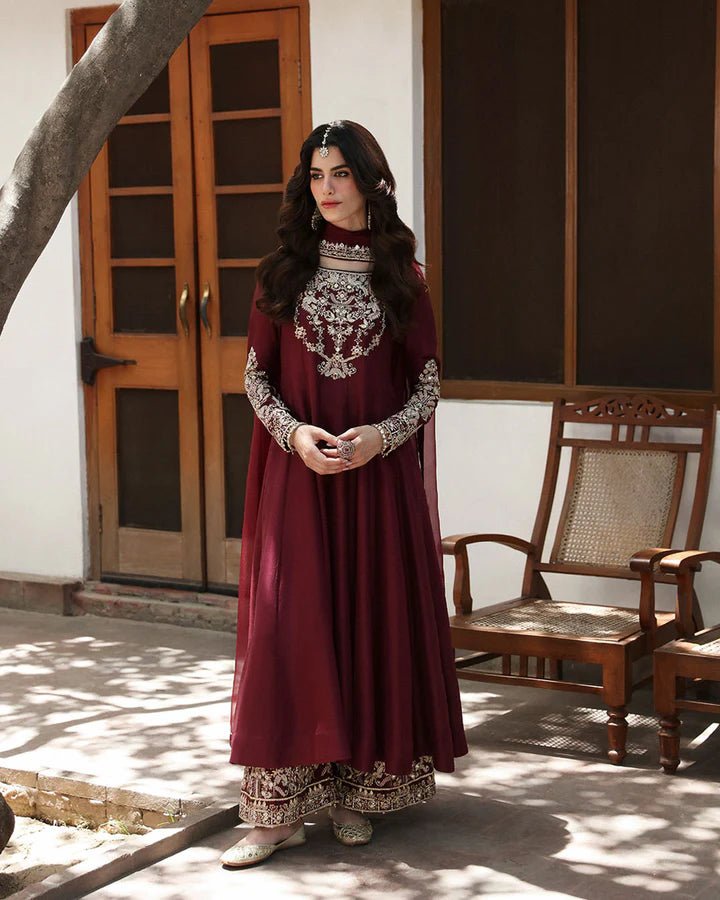 Model wearing a maroon dress with intricate gold embroidery, from Faiza Saqlain's Mehermah Luxe Formals '24 collection, highlighting Pakistani clothes online in UK and wedding clothes.