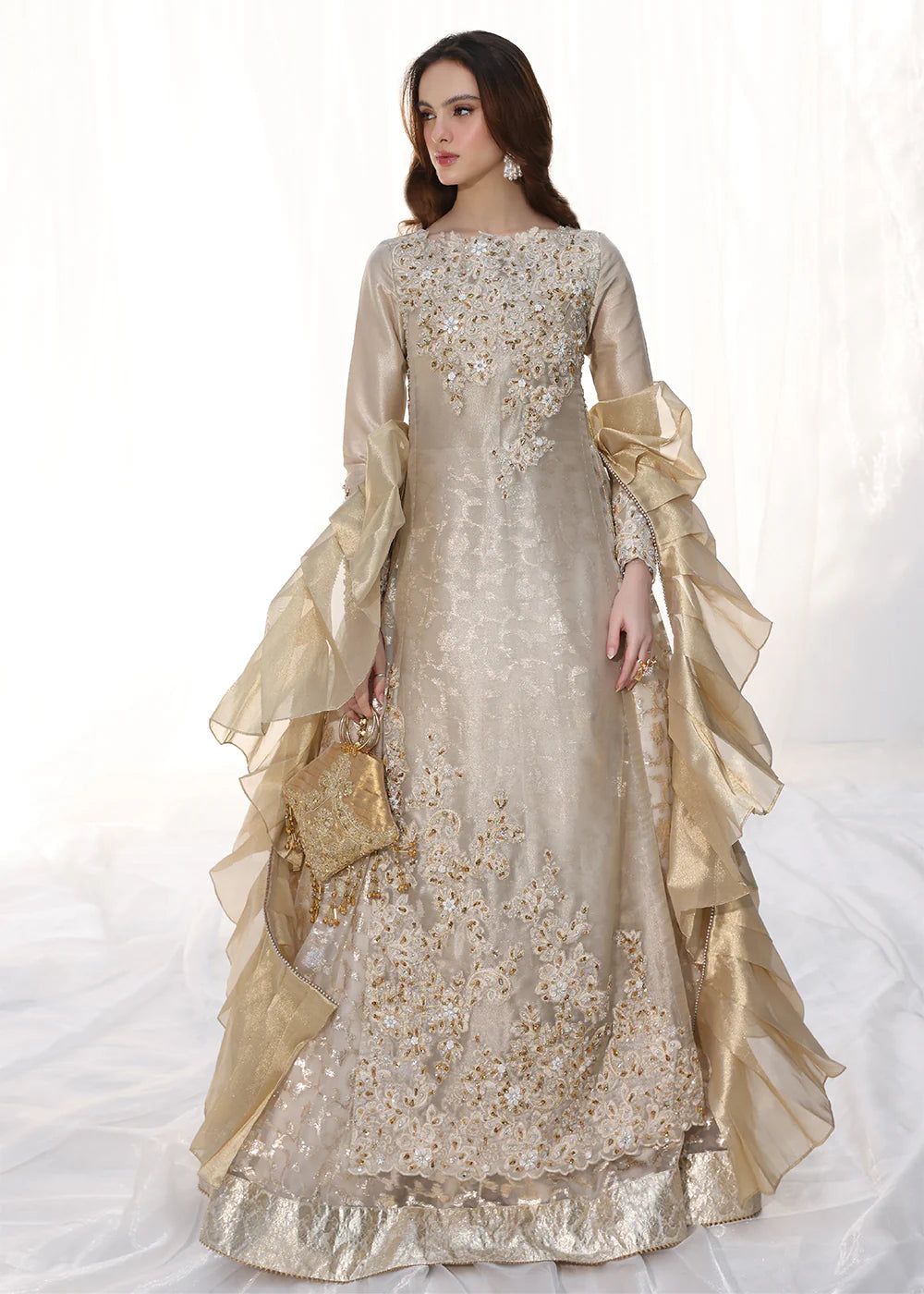 Model wearing gold embellished long dress with ruffled sleeves from Musferah Saad Golden Whispers, Pakistani Luxury pret in UK.