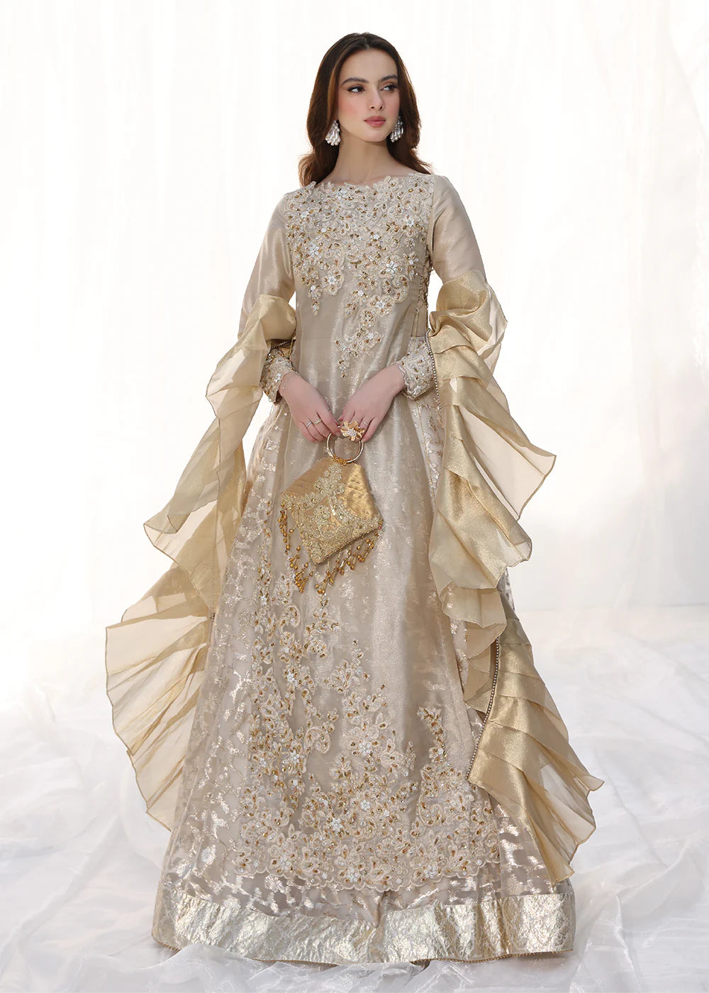 Model wearing gold embellished long dress with ruffled sleeves from Musferah Saad Golden Whispers, Pakistani Luxury pret in UK.