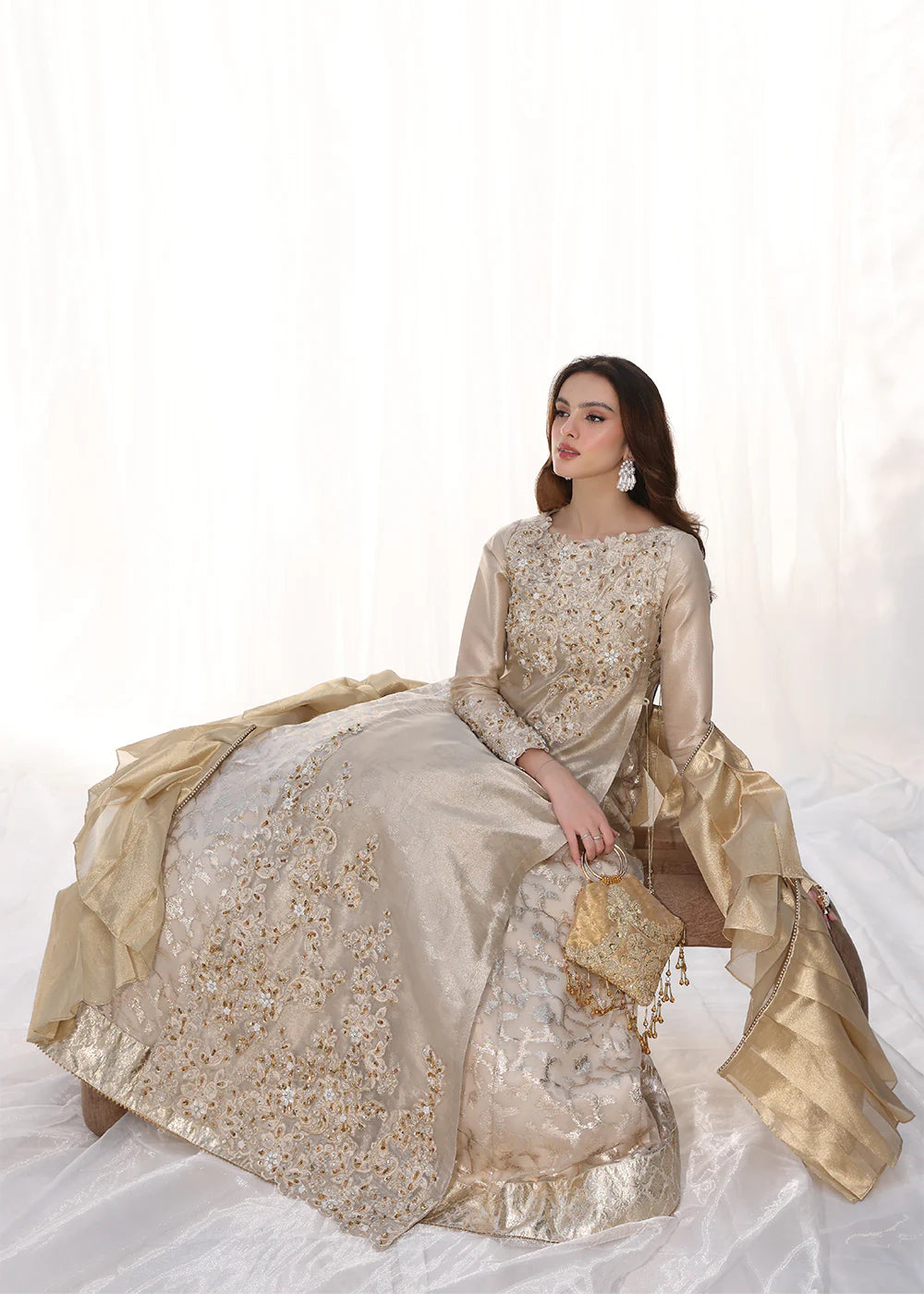 Model wearing gold embellished long dress with ruffled sleeves from Musferah Saad Golden Whispers, Pakistani Luxury pret in UK.