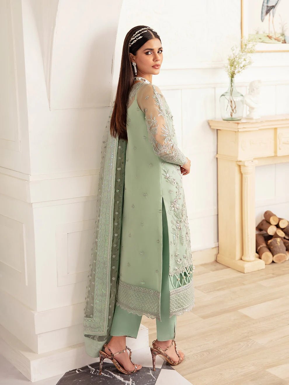 Model wearing a mint green embroidered dress, featuring intricate silver detailing and sheer sleeves from Gulaal. Ideal for showcasing Gulaal's luxury pret collection and Pakistani clothes online in the UK.