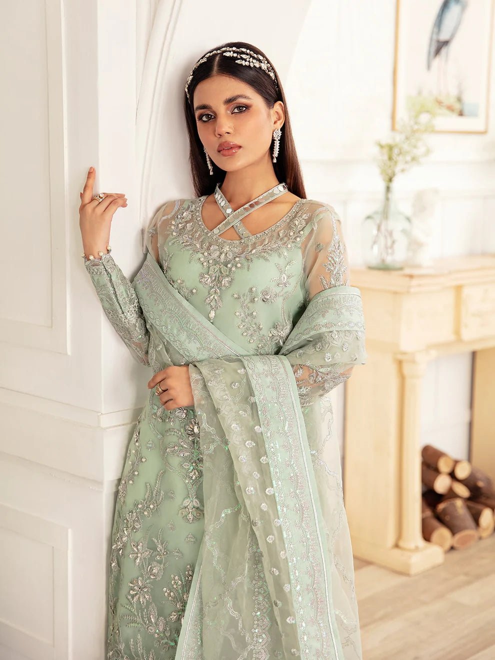 Model wearing a mint green embroidered dress, featuring intricate silver detailing and sheer sleeves from Gulaal. Ideal for showcasing Gulaal's luxury pret collection and Pakistani clothes online in the UK.