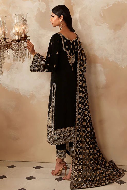 Model wearing a black Gulaal Shehrnaaz Raw Silk outfit with intricate embroidery and sequins, paired with an embroidered chiffon dupatta and dyed silk trousers, perfect for festive occasions.