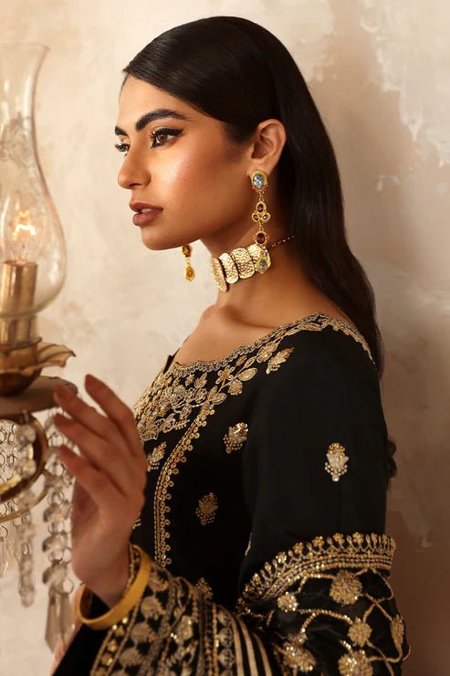 Model wearing a black Gulaal Shehrnaaz Raw Silk outfit with intricate embroidery and sequins, paired with an embroidered chiffon dupatta and dyed silk trousers, perfect for festive occasions.