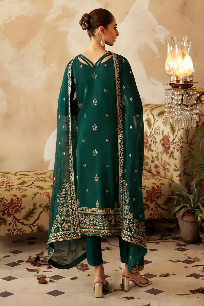 Model in a deep green Gulaal Shehrnaaz Raw Silk outfit with intricate embroidery and sequins, featuring a silk dupatta and matching trousers, perfect for festive occasions. Available online.