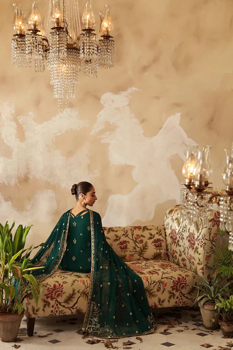 Model in a deep green Gulaal Shehrnaaz Raw Silk outfit with intricate embroidery and sequins, featuring a silk dupatta and matching trousers, perfect for festive occasions. Available online.