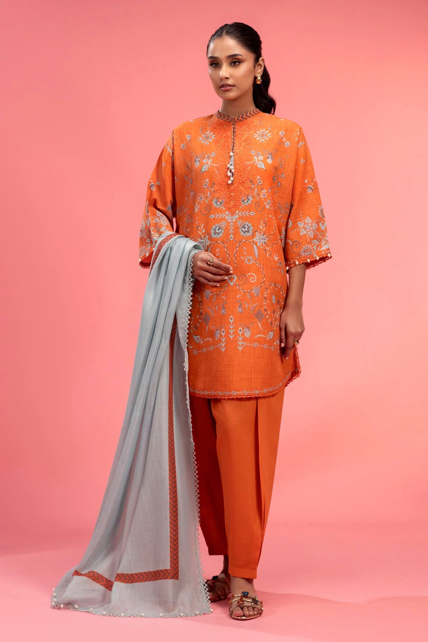 Model wearing bright orange embroidered outfit with light grey dupatta from Sana Safinaz, Mahay Spring '25, Pakistani casual pret in UK.