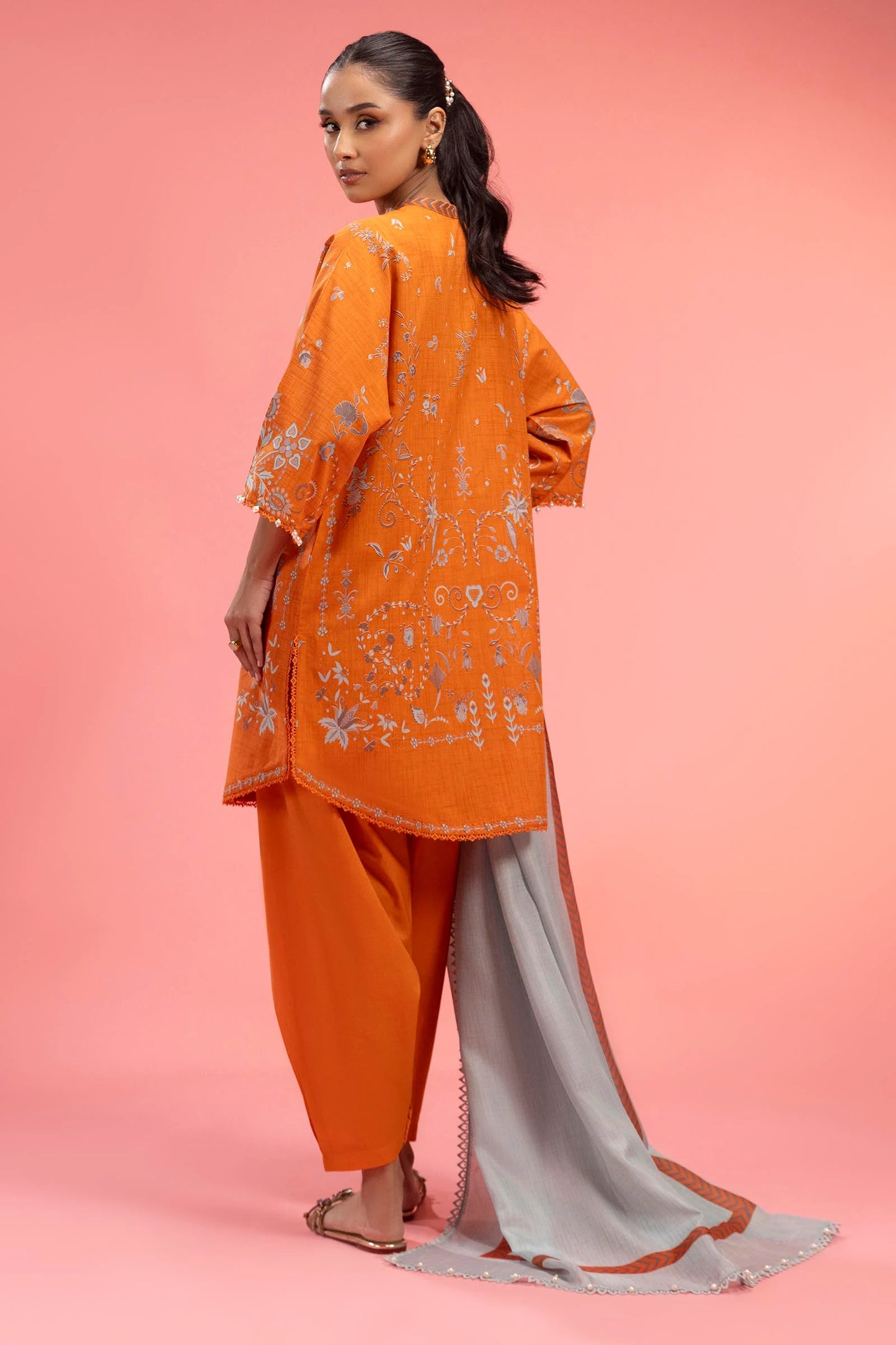 Model wearing bright orange embroidered outfit with light grey dupatta from Sana Safinaz, Mahay Spring '25, Pakistani casual pret in UK.