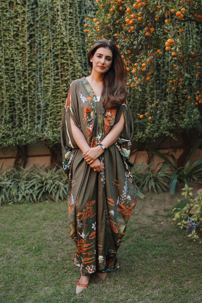Model wearing olive green kaftan with orange and white floral motifs from Saira Rizwan, Pakistani Luxury pret, Pakistani clothes online in UK.