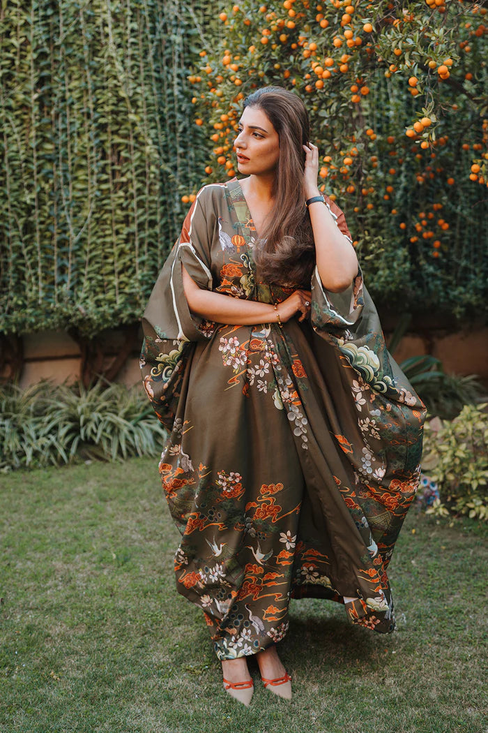 Model wearing olive green kaftan with orange and white floral motifs from Saira Rizwan, Pakistani Luxury pret, Pakistani clothes online in UK.