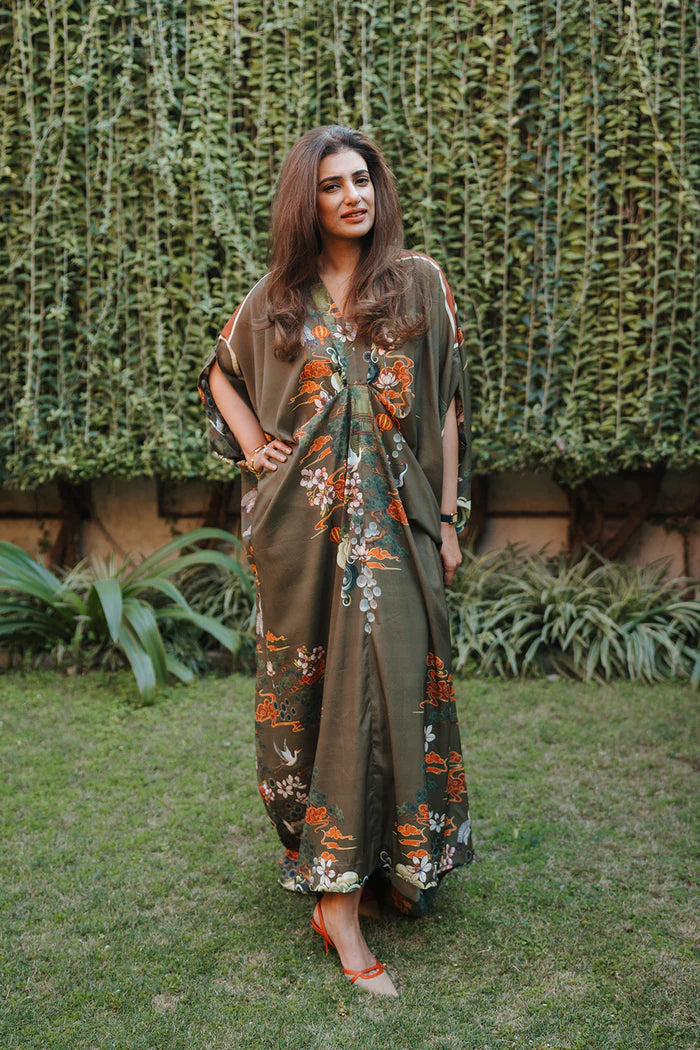 Model wearing olive green kaftan with orange and white floral motifs from Saira Rizwan, Pakistani Luxury pret, Pakistani clothes online in UK.