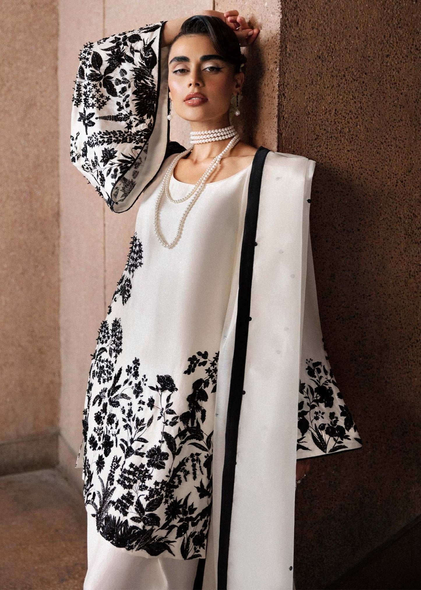 Model wearing a black and white Tusk dress from Hussain Rehar's Luxury Pret Eid '24 collection. Pakistani clothes online in UK.