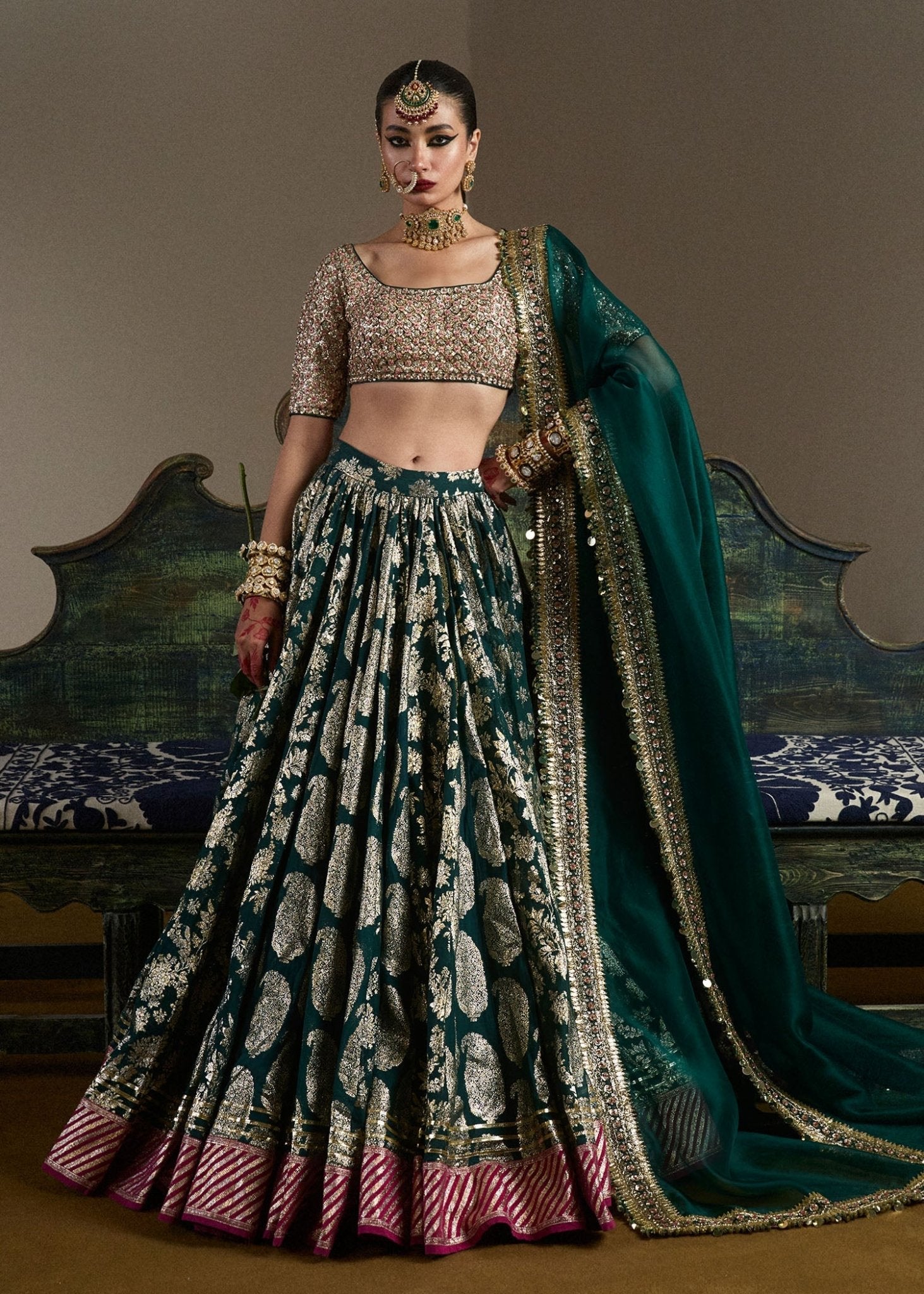 model wearing Neelam green and gold bridal lehenga with embroidered blouse and dupatta from Hussain Rehar, available in the UK. Shop Pakistani bridal dresses online.