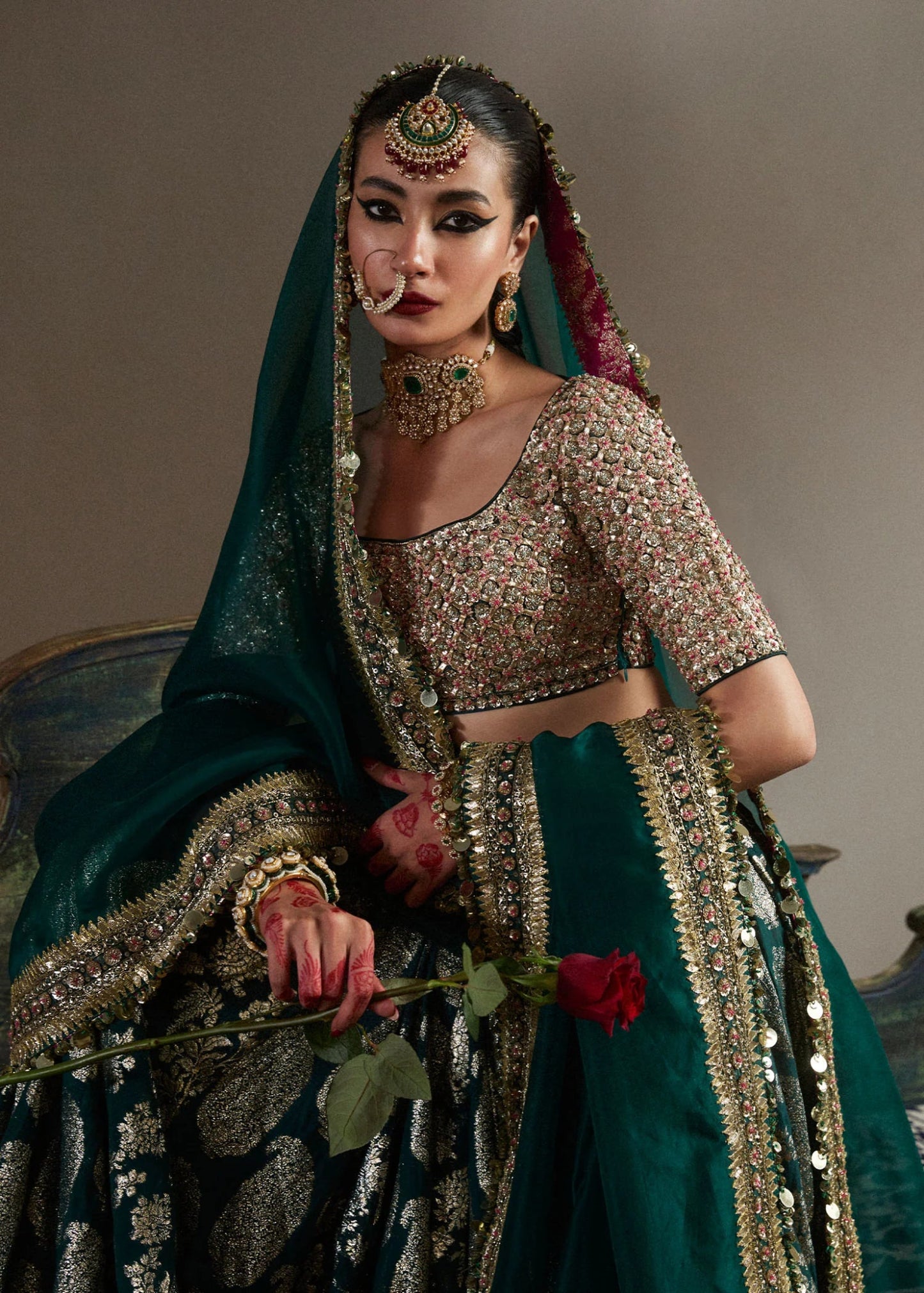 model wearing Neelam green and gold bridal lehenga with embroidered blouse and dupatta from Hussain Rehar, available in the UK. Shop Pakistani bridal dresses online.