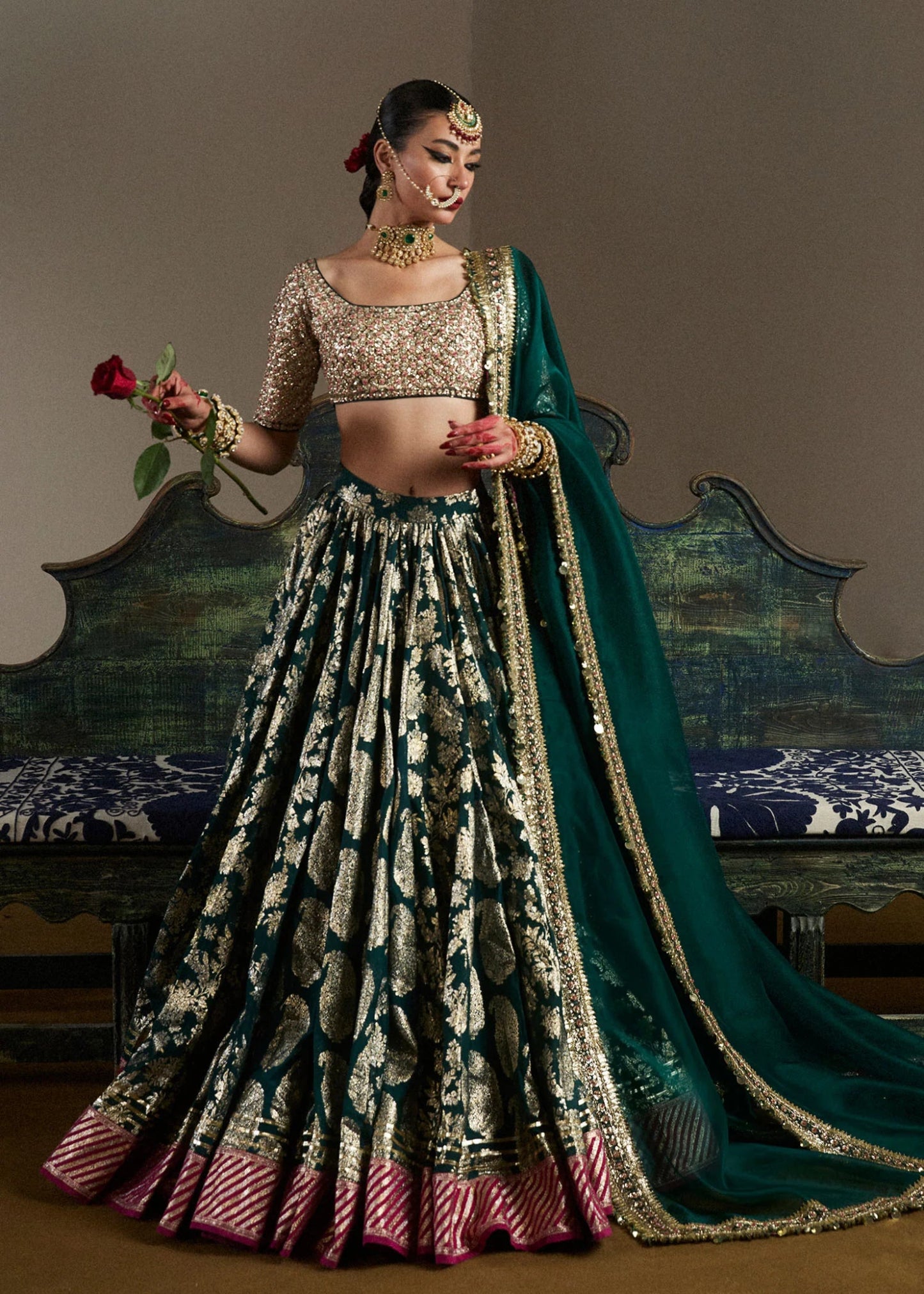 model wearing Neelam green and gold bridal lehenga with embroidered blouse and dupatta from Hussain Rehar, available in the UK. Shop Pakistani bridal dresses online.