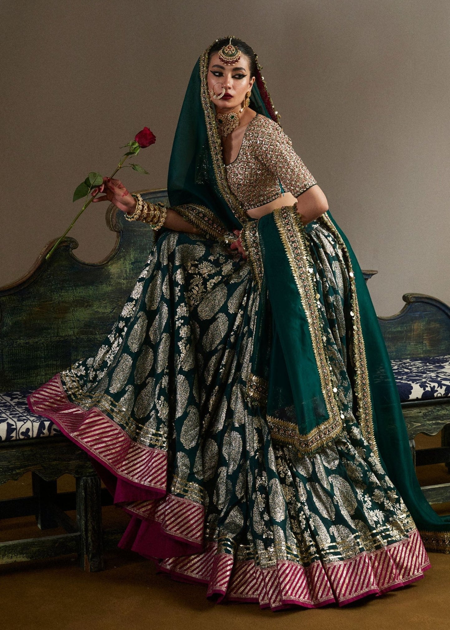 model wearing Neelam green and gold bridal lehenga with embroidered blouse and dupatta from Hussain Rehar, available in the UK. Shop Pakistani bridal dresses online.