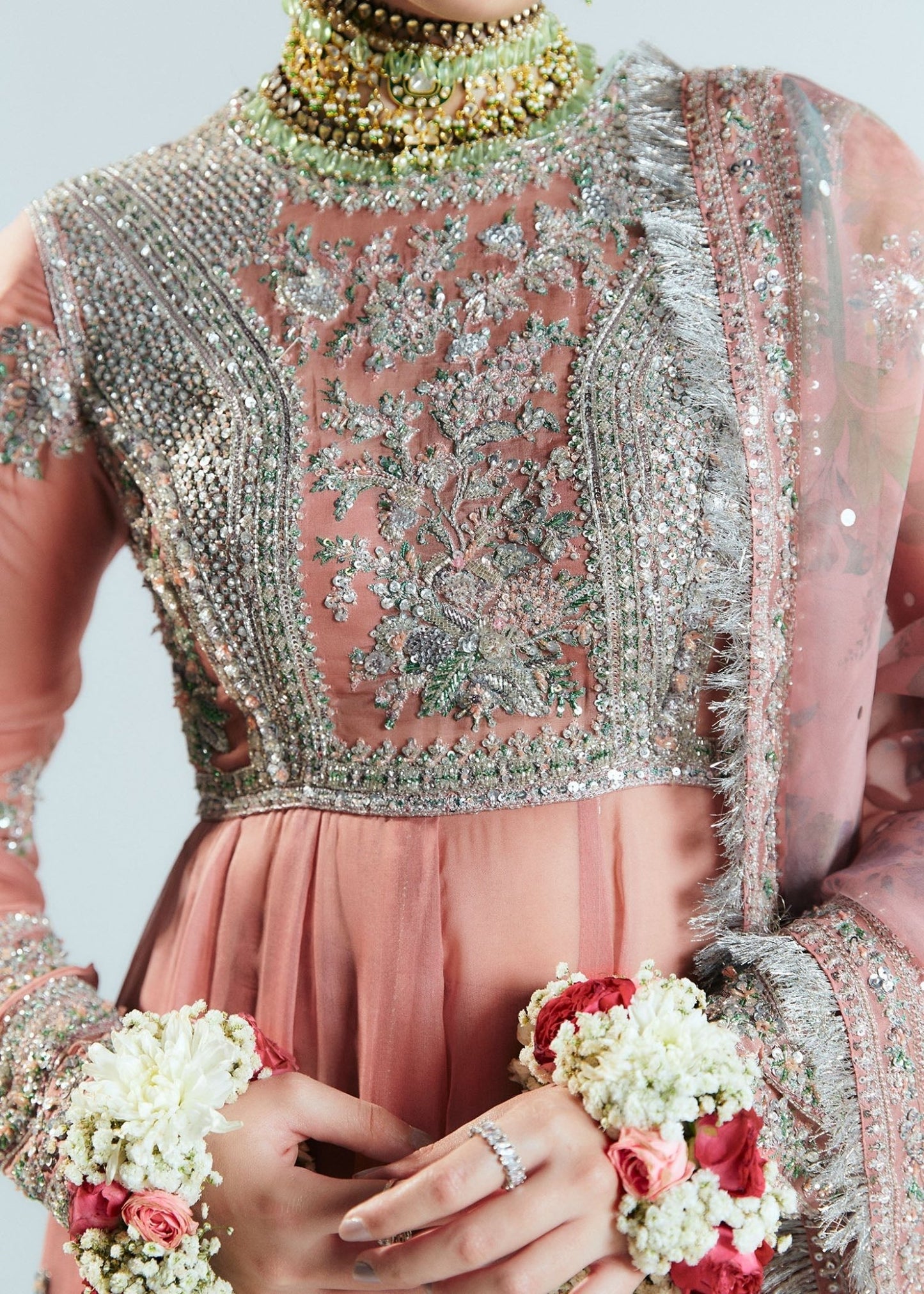 Model wearing Hussain Rehar Sitaray Formals Tropica, a peach - colored dress with intricate silver embroidery and embellishments, ideal for weddings.