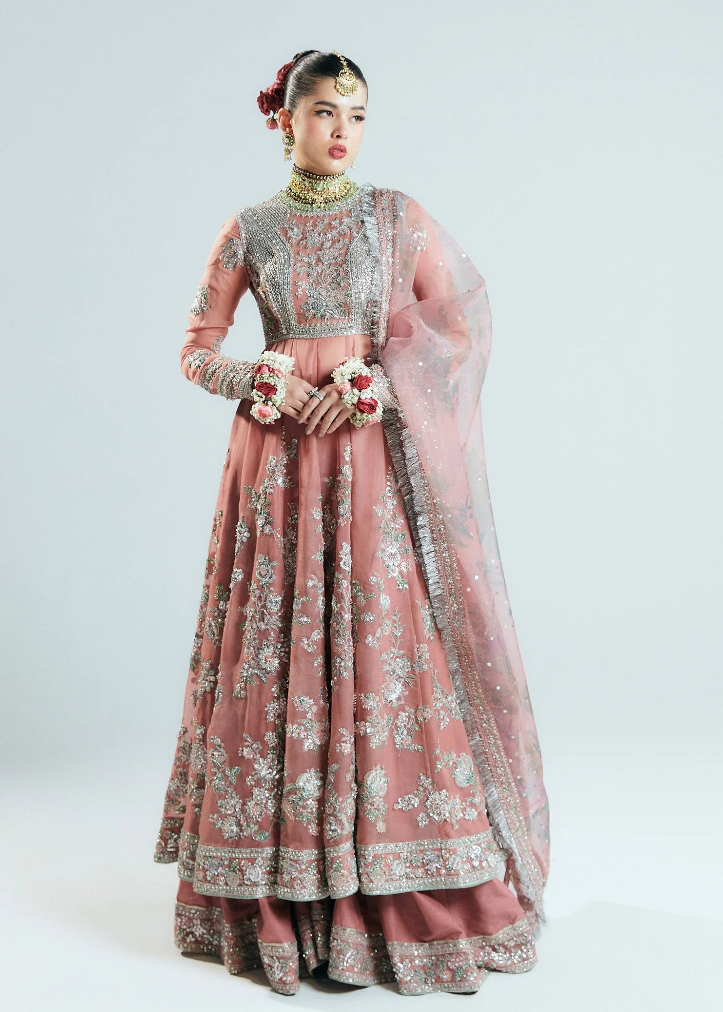 Model wearing Hussain Rehar Sitaray Formals Tropica, a peach - colored dress with intricate silver embroidery and embellishments, ideal for weddings.