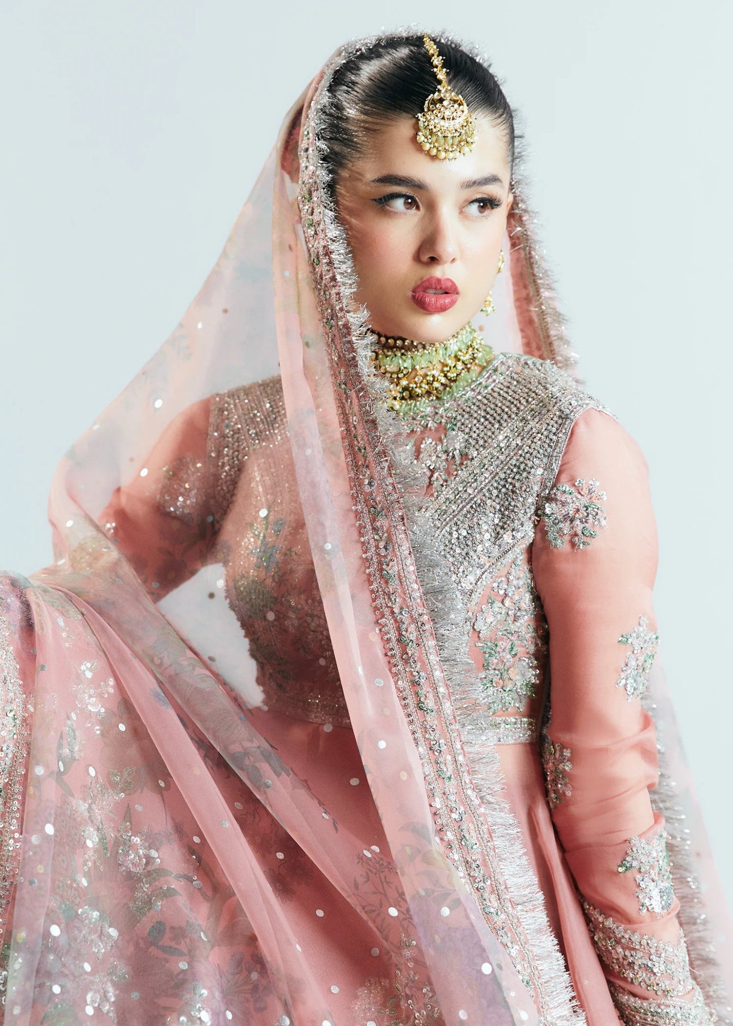 Model wearing Hussain Rehar Sitaray Formals Tropica, a peach - colored dress with intricate silver embroidery and embellishments, ideal for weddings.