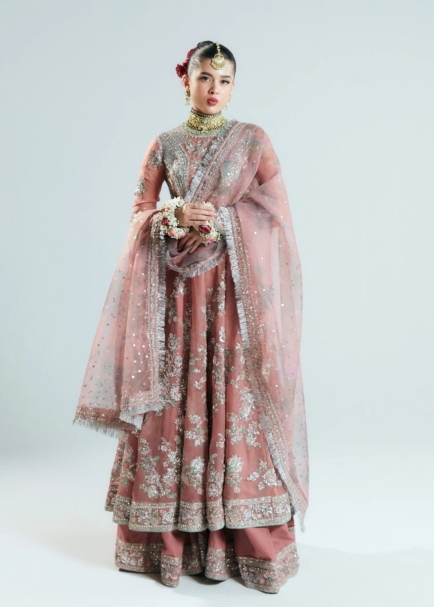 Model wearing Hussain Rehar Sitaray Formals Tropica, a peach - colored dress with intricate silver embroidery and embellishments, ideal for weddings.