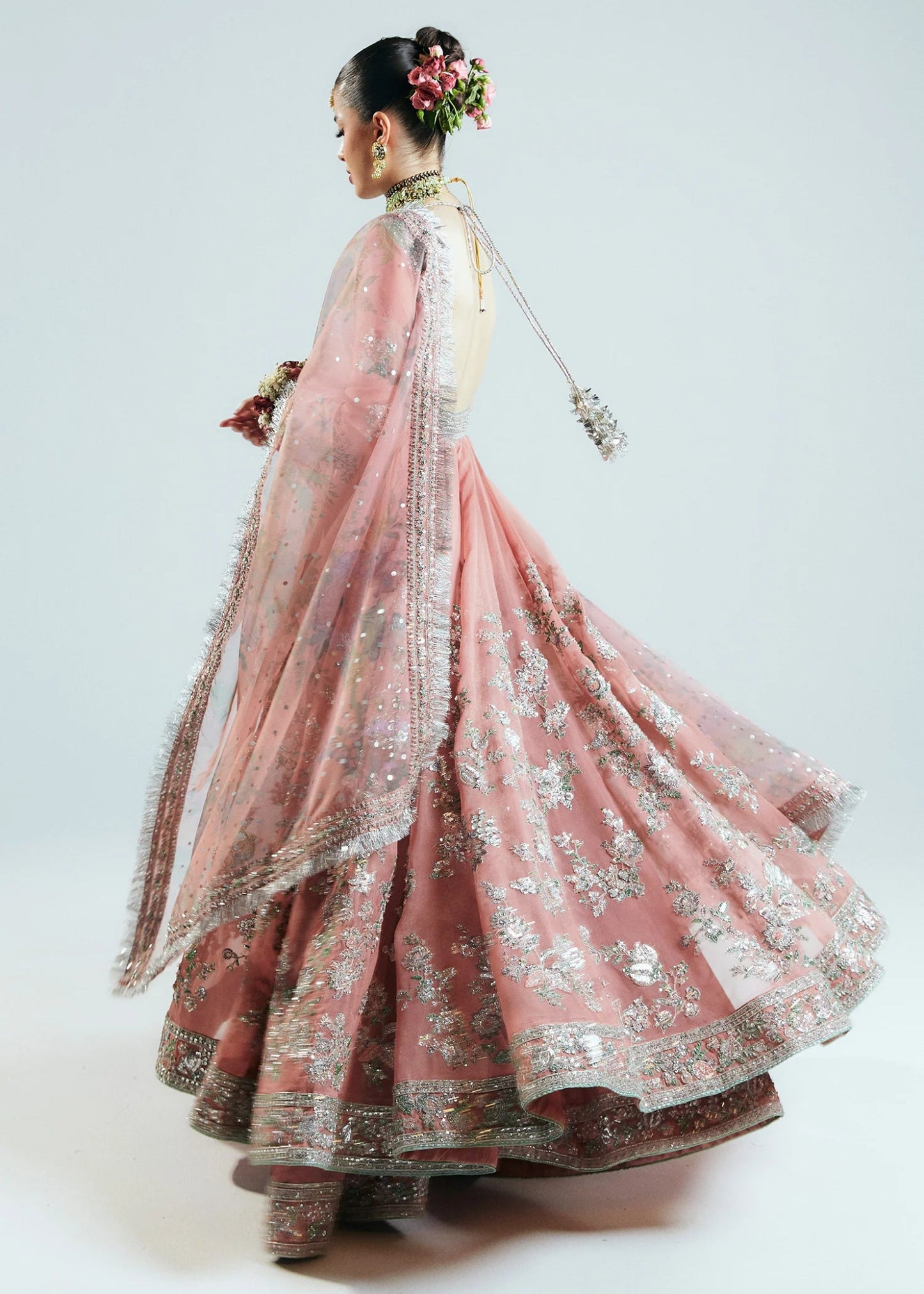 Model wearing Hussain Rehar Sitaray Formals Tropica, a peach - colored dress with intricate silver embroidery and embellishments, ideal for weddings.