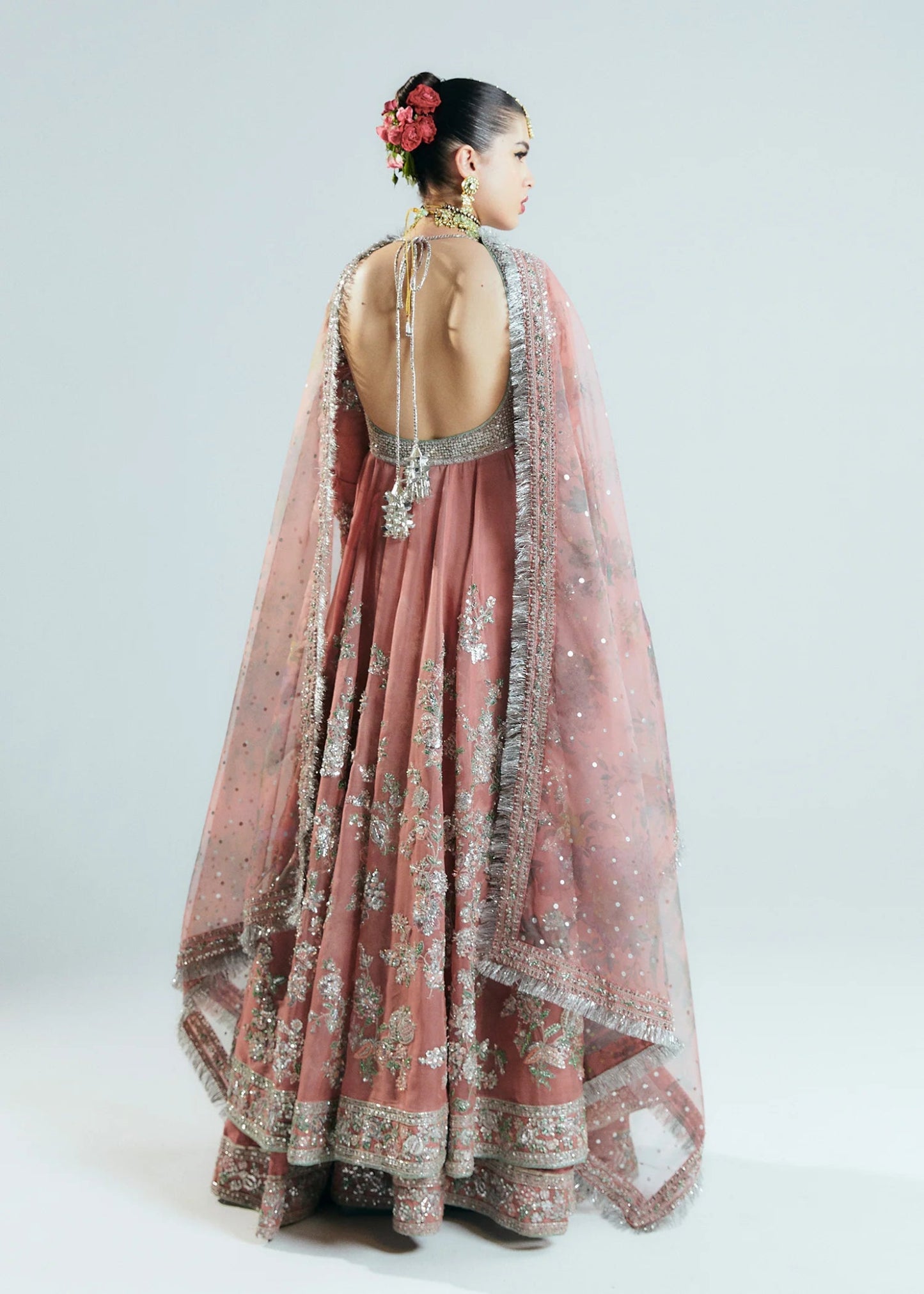 Model wearing Hussain Rehar Sitaray Formals Tropica, a peach - colored dress with intricate silver embroidery and embellishments, ideal for weddings.