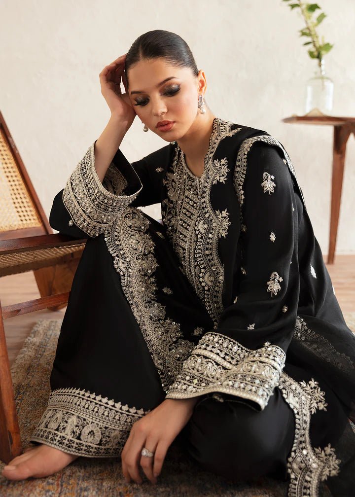 Model wearing a black Soha dress from Kanwal Malik's Amelie Luxury Pret collection. The outfit features intricate silver embroidery. Perfect for Pakistani clothes online in the UK, especially for wedding clothes and festive occasions.
