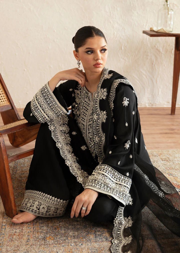 Model wearing a black Soha dress from Kanwal Malik's Amelie Luxury Pret collection. The outfit features intricate silver embroidery. Perfect for Pakistani clothes online in the UK, especially for wedding clothes and festive occasions.