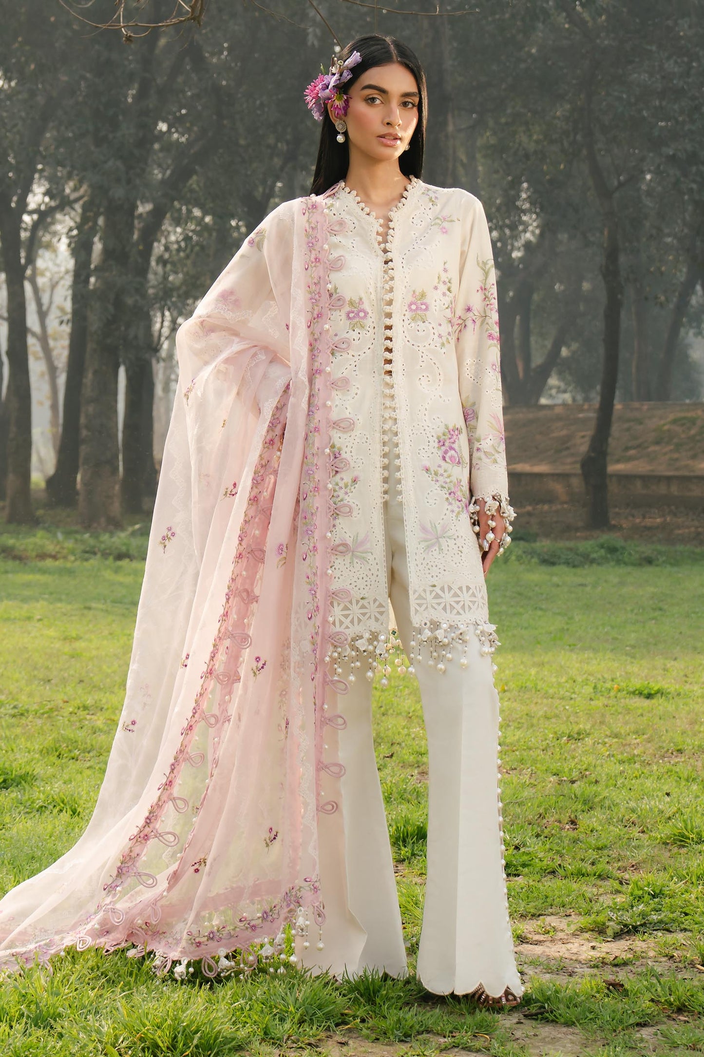 Model wearing ivory and pink embroidered outfit from Sana Safinaz, Luxury Lawn '25, perfect for Pakistani clothes online in UK.