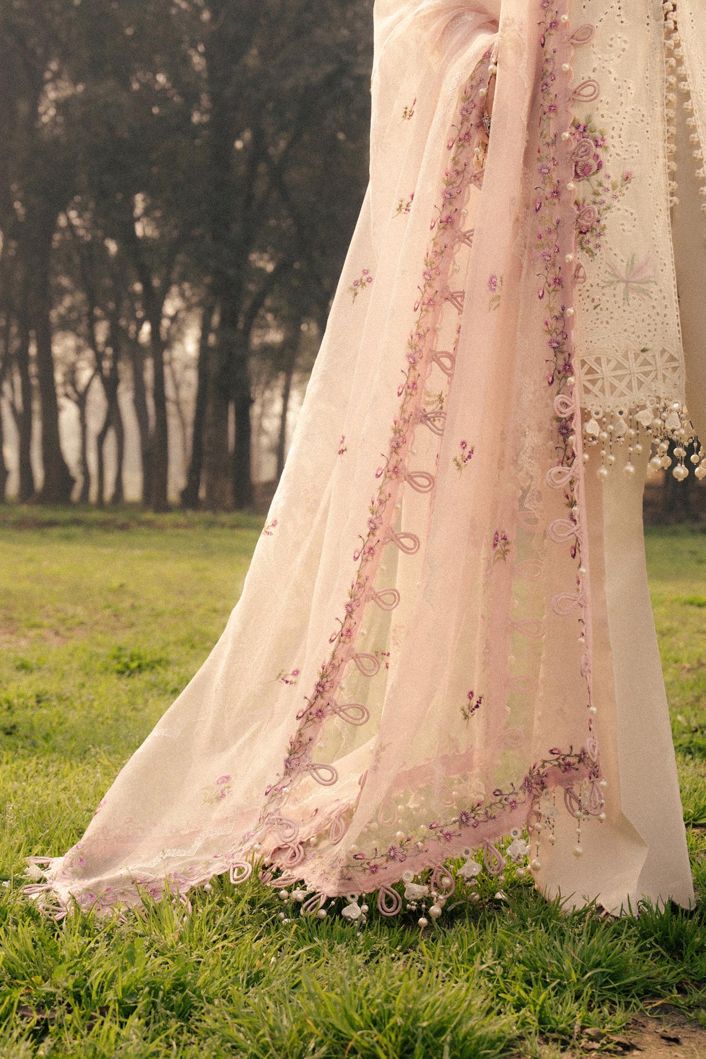 Model wearing ivory and pink embroidered outfit from Sana Safinaz, Luxury Lawn '25, perfect for Pakistani clothes online in UK.