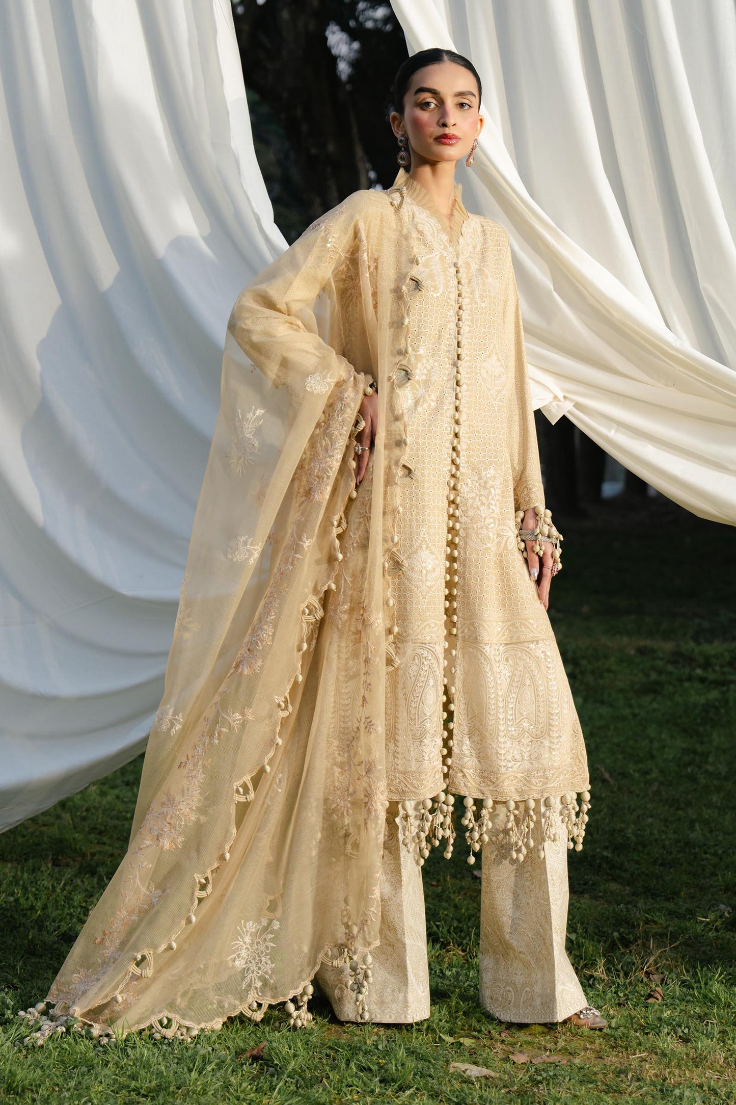 Model wearing beige embroidered outfit from Sana Safinaz, Luxury Lawn '25, perfect for Pakistani clothes online in UK and luxury pret.
