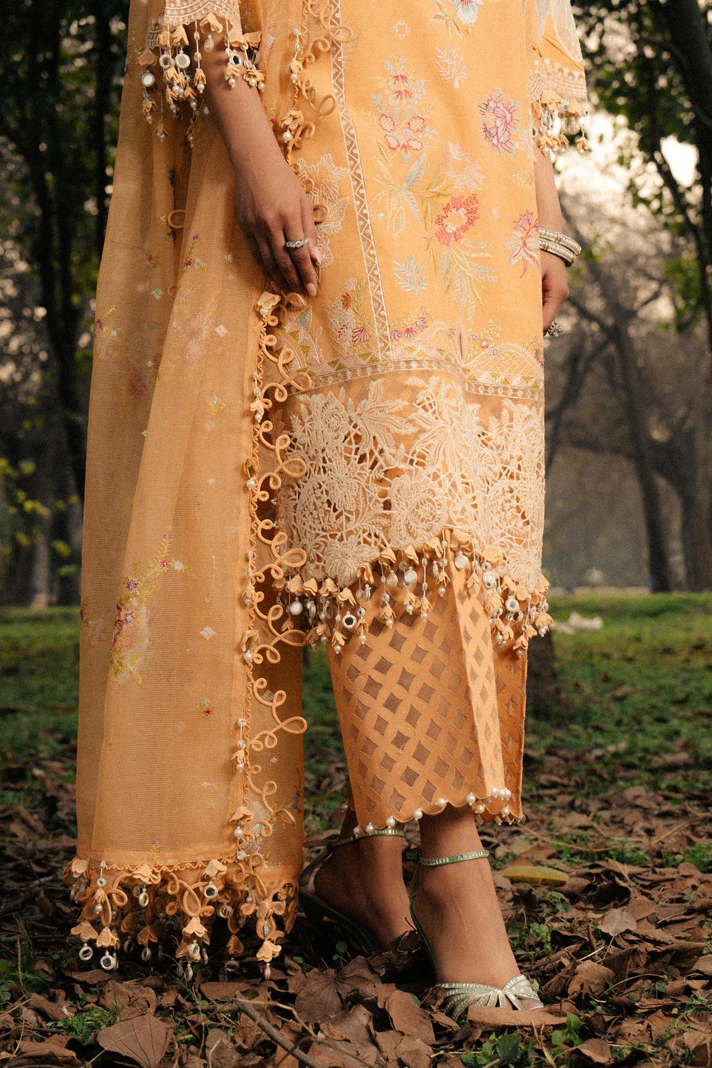 Model wearing mustard yellow embroidered dress with lace detailing from Sana Safinaz Luxury Lawn '25, Pakistani clothes online in UK.