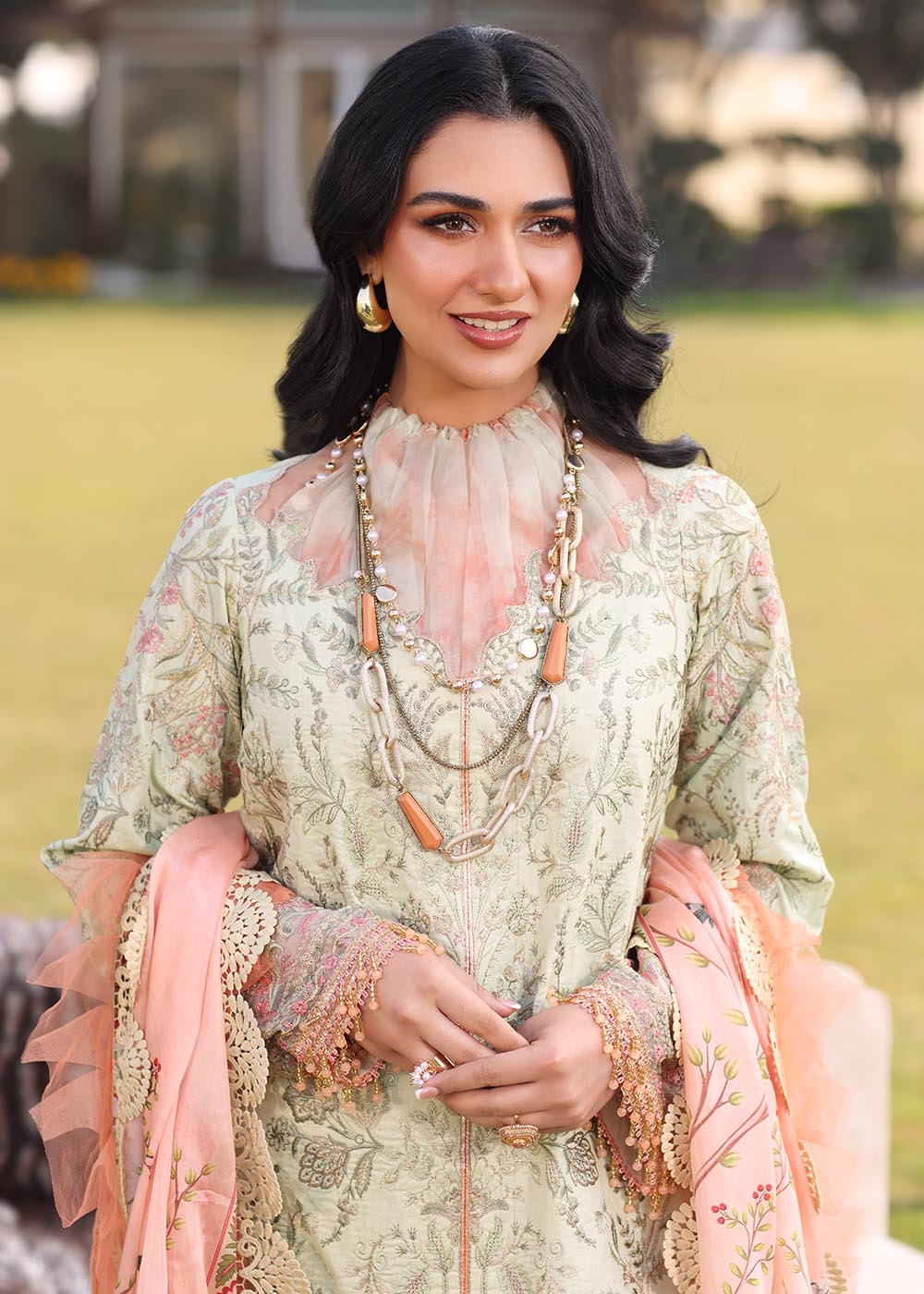 Model wearing light green and peach printed dress with floral dupatta from Musferah Saad Pretty Girls Luxury Lawn '25 Lilia, Pakistani clothes online in UK.